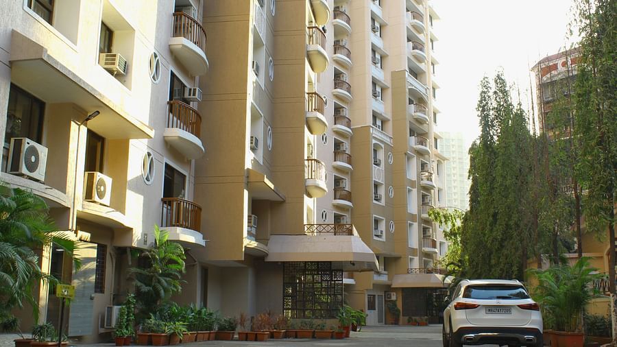 A long shot of the facade of the apartment where a car is heading towards the entrance