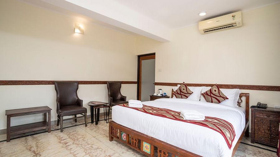Grand Riverside Bedroom from a different angle shows the chairs and table at the side - Stone Wood Riverfront Resort, Siolim
