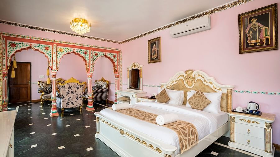 The large plush bed and beautifully decorated pillars of the Maharaja Bedroom - Stone Wood Riverfront Resort, Siolim