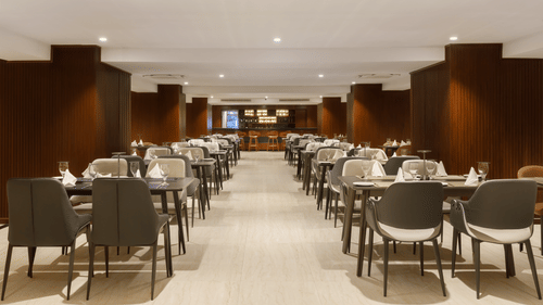 The spacious restaurant at Royal Tulip, Kathmandu, with multiple dining tables set for guests.