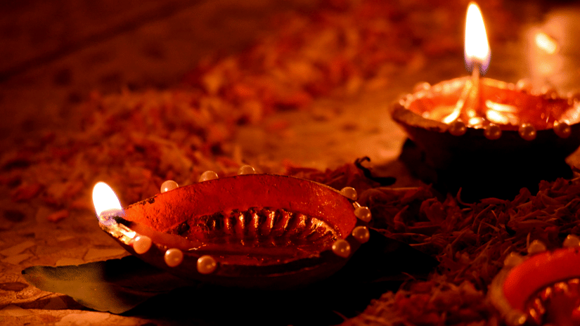 A couple of traditional lamps lit facing in opposite directions during Karthika Pournami