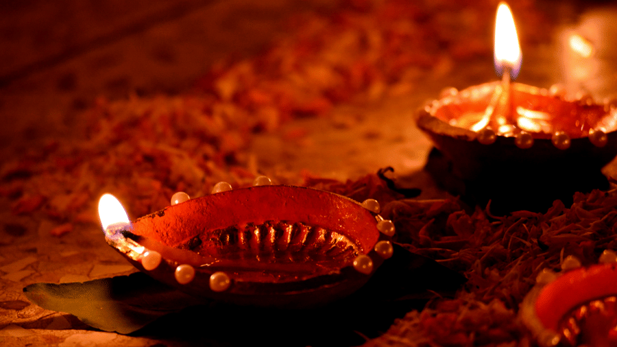 A couple of traditional lamps lit facing in opposite directions during Karthika Pournami