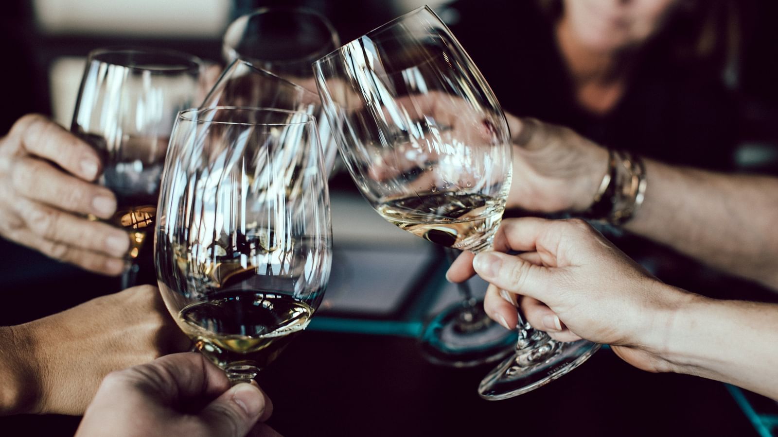 A group of people toasting with glasses of wine, celebrating a special occasion or enjoying a social gathering.