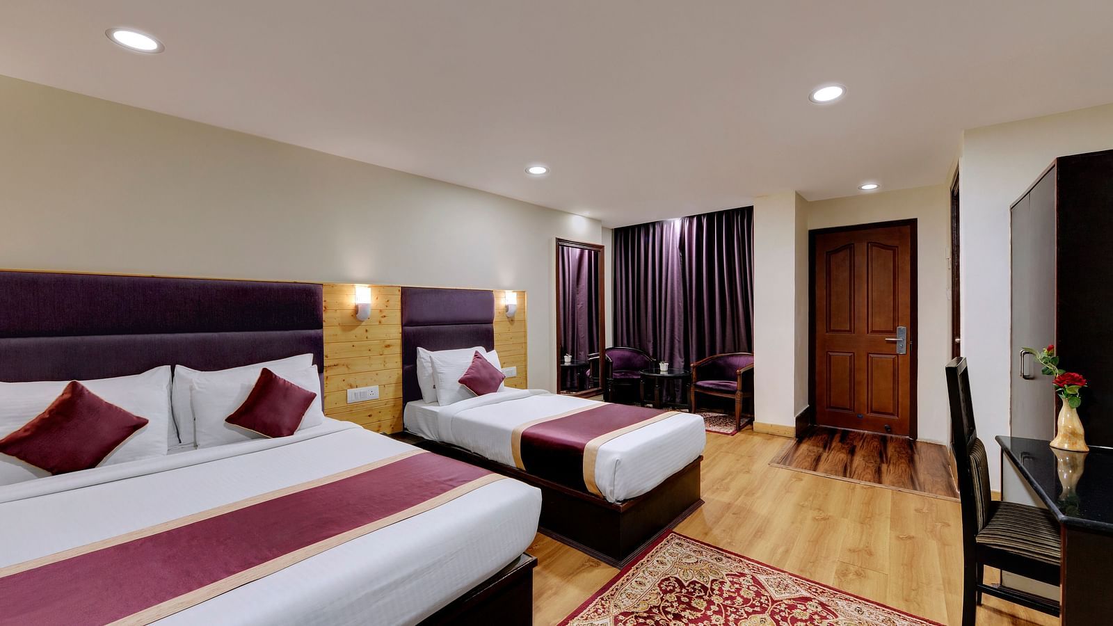  Deluxe Triple Room at Sumitel Darjeeling. A room with three beds, ample space, and a window with a view.