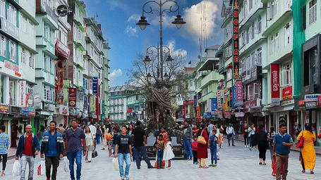 A bustling shopping street in Kolkata crowded with pedestrians, vibrant storefronts, and colourful signage capturing the city’s energetic urban life.