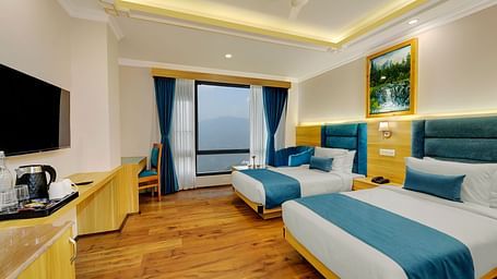 An image of the family suite with two beds, bed side tables, flat screen TV, and a window - Yashshree Sikkim Blossom, Gangtok
