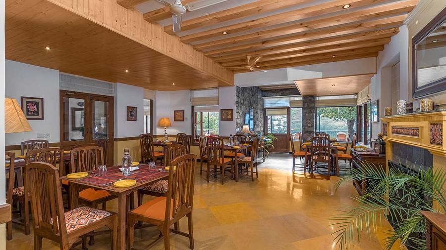 Indoor restaurant at Fishermen's Lodge, Bhimtal, featuring stylish wooden furnishings and a warm, inviting atmosphere.