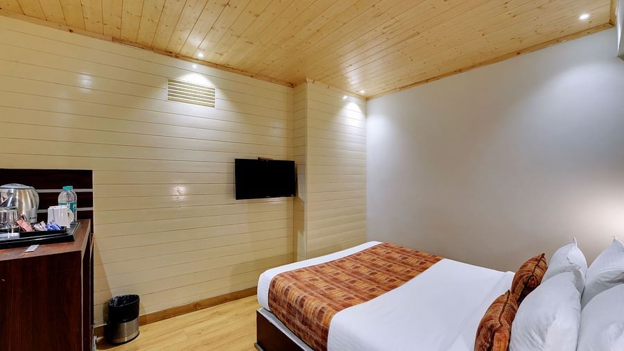 An image of a room with a queen size bed, TV and room amenities like tea coffee maker - Sumitel Vista TV Tower