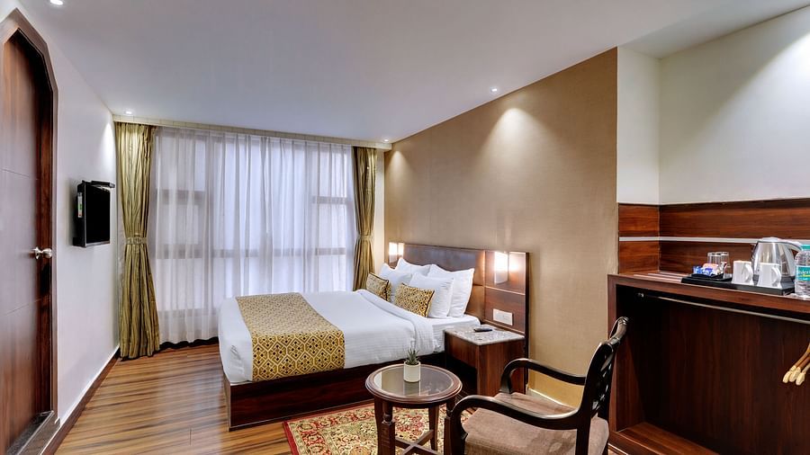 An image of a room with a queen size bed, TV, chair and a table, and room amenities like tea coffee maker - Sumitel Vista TV Tower