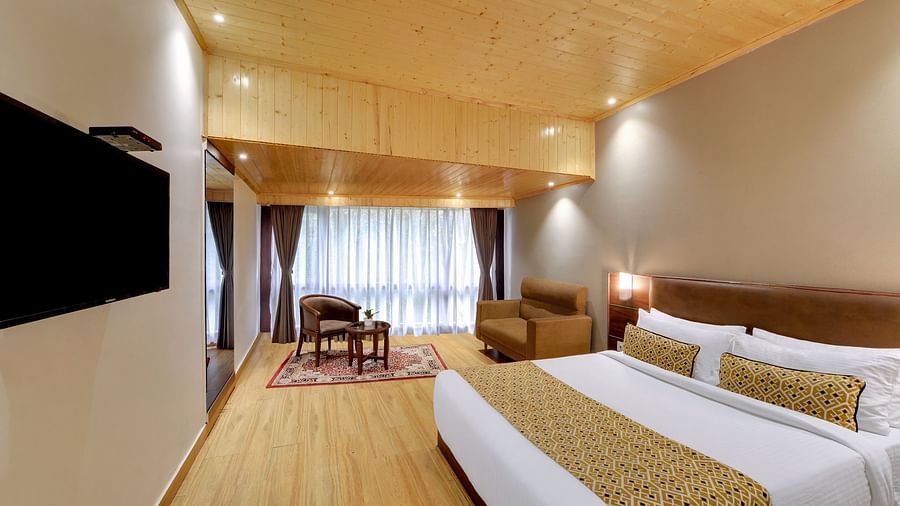An image of a room with a queen size bed, TV, sofa, lamps and minimal decoration - Sumitel Vista TV Tower