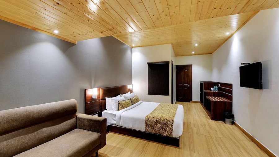 An image of a room with a queen size bed, TV, sofa, lamps and minimal decoration - Sumitel Vista TV Tower