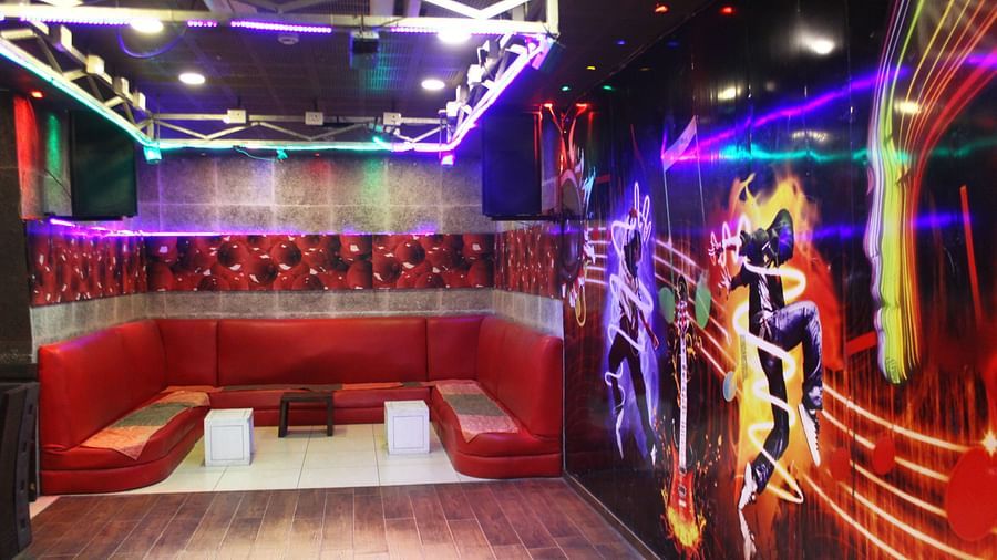 Another view of the dance club featuring the red sofa, colourful dance-themed murals and club lighting - TGI Apple Inn, Jaipur 