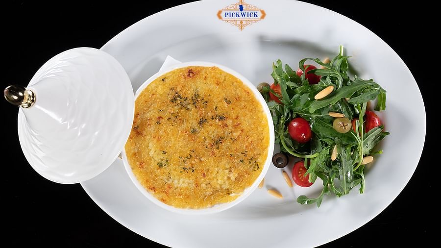 image of well plated food served with green slald at the pickwick - The Claridges New Delhi
