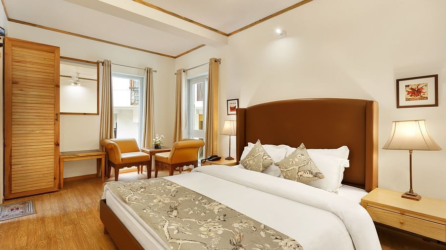A cosy room with comfy bed chairs and a cupboard near window in Pinewood Nainital 