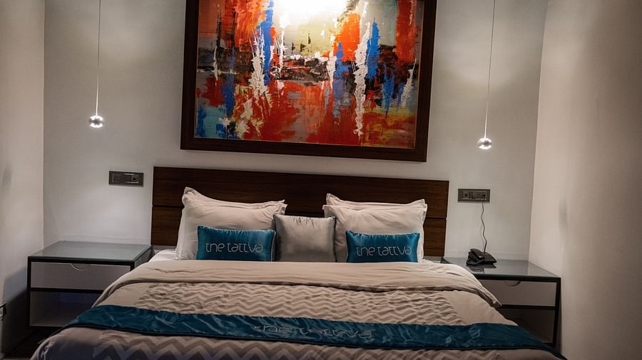 image of the bedroom featuring a double bed with a beautiful paining hanging above it - The Tattva Boutique Resort