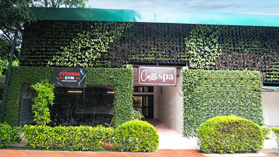 Exterior view of the spa building surrounded by lush green hedge walls and manicured bushes - Wood Castle Spa & Resort, Jim Corbett