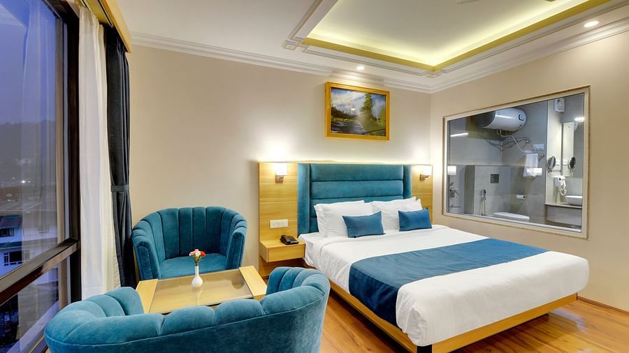 An image of a family suite with a bed, lamps, sofa set, table and a window - Yashshree Sikkim Blossom, Gangtok