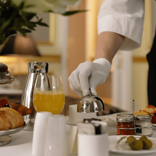 Image of a person with gloves serving food on  a table