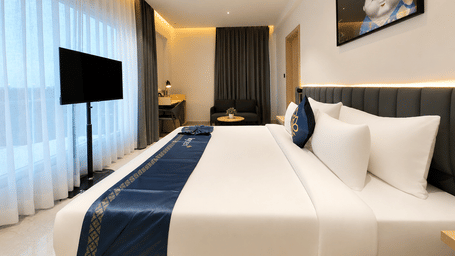Luxury Suite with a queen size bed facing a wall mounted television at Hotel Kyzen, Shamshabad Airport, Hyderabad.