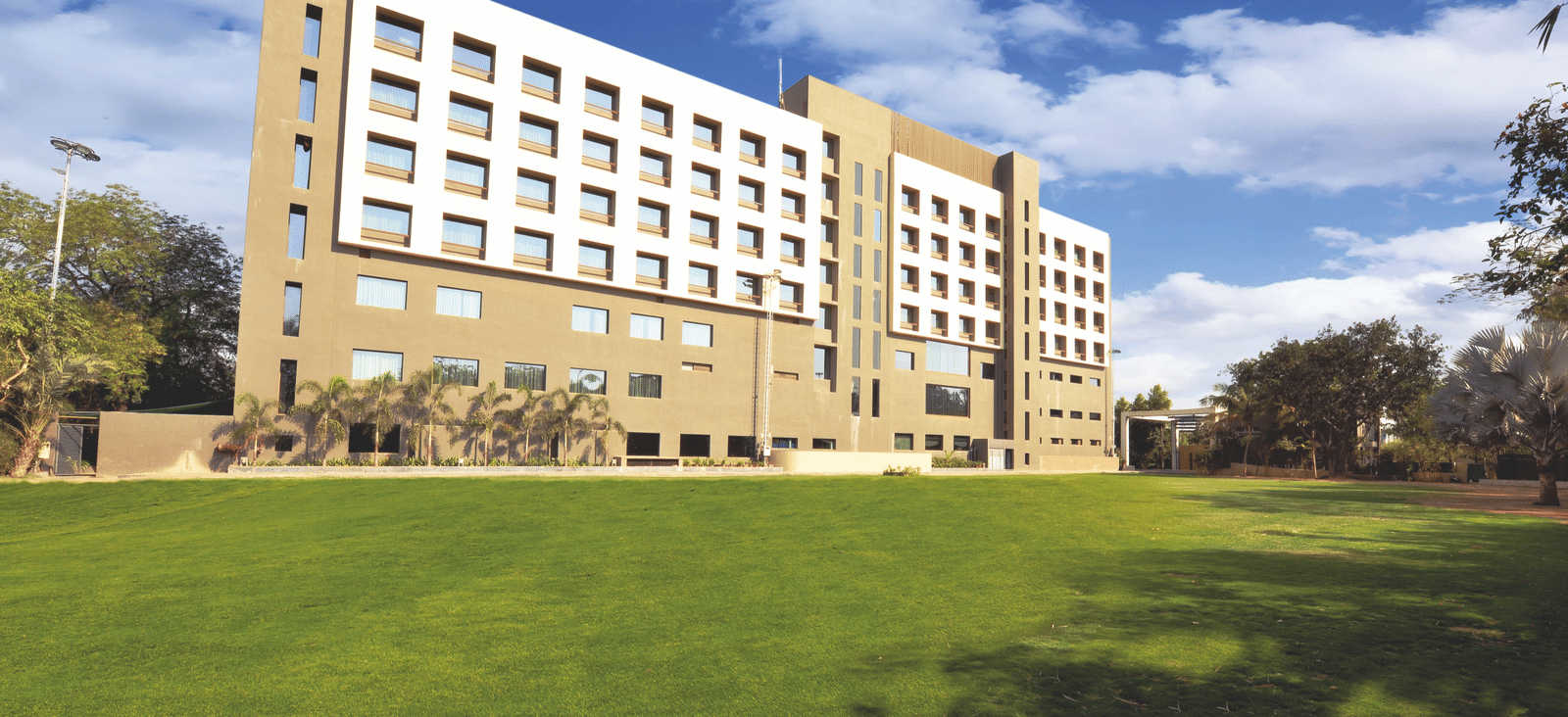 Exterior view of hotel building with expansive lawn – Narayani Heights Hotel & Resorts