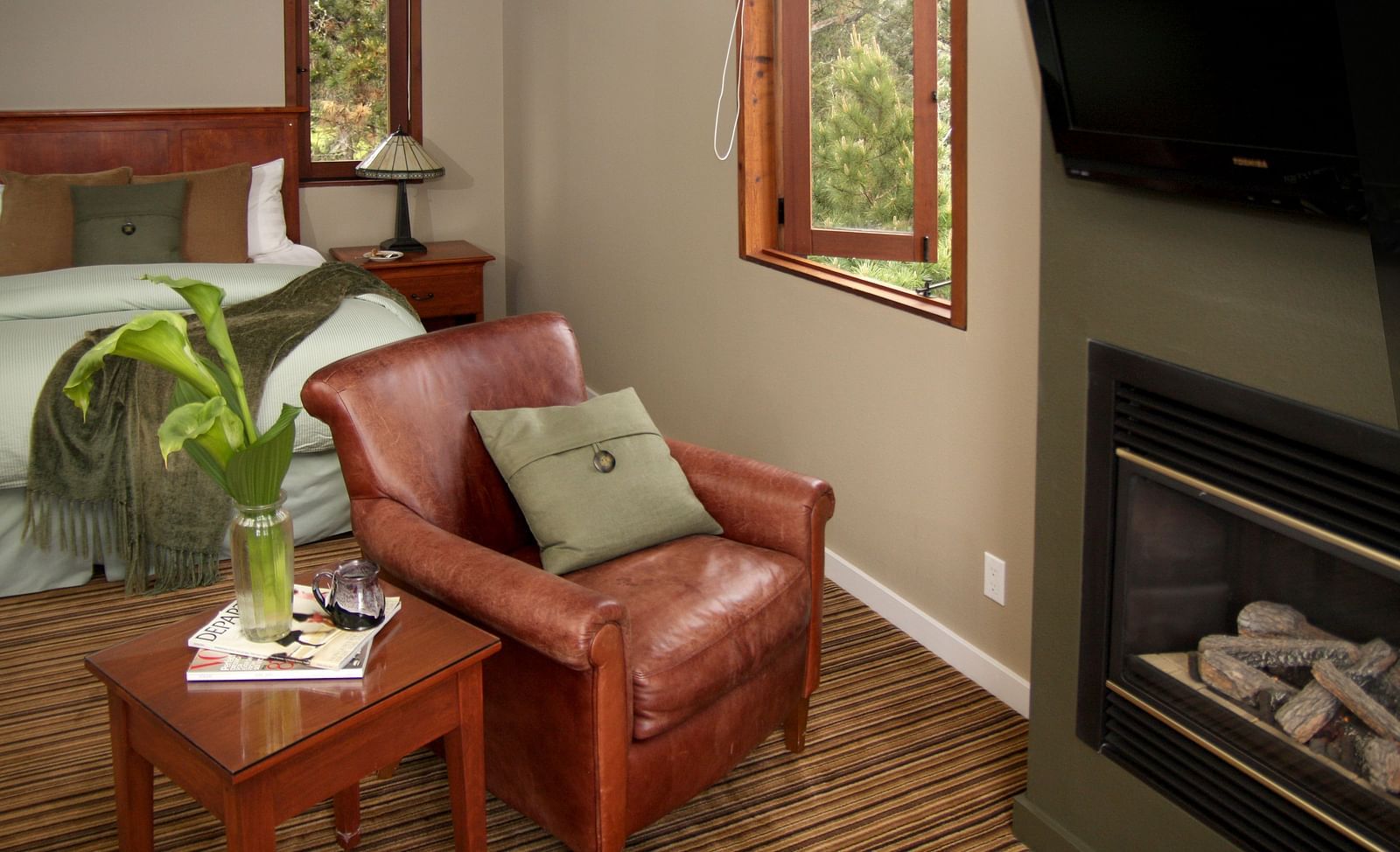 A cosy seating area by the fireplace with plush cushions - Brewery Gulch Inn & Spa