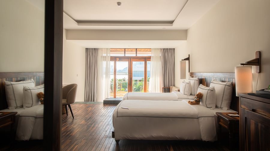 A bedroom at our resort seen from the entrance with a plush bed and comfortable furniture to rest - Alibu Resort Nha Trang