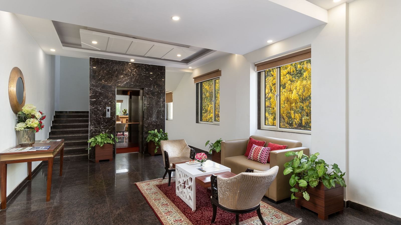 A spacious hotel lobby with comfortable seating, elegant decor, and plenty of natural light | Inde Hotel Cyber City