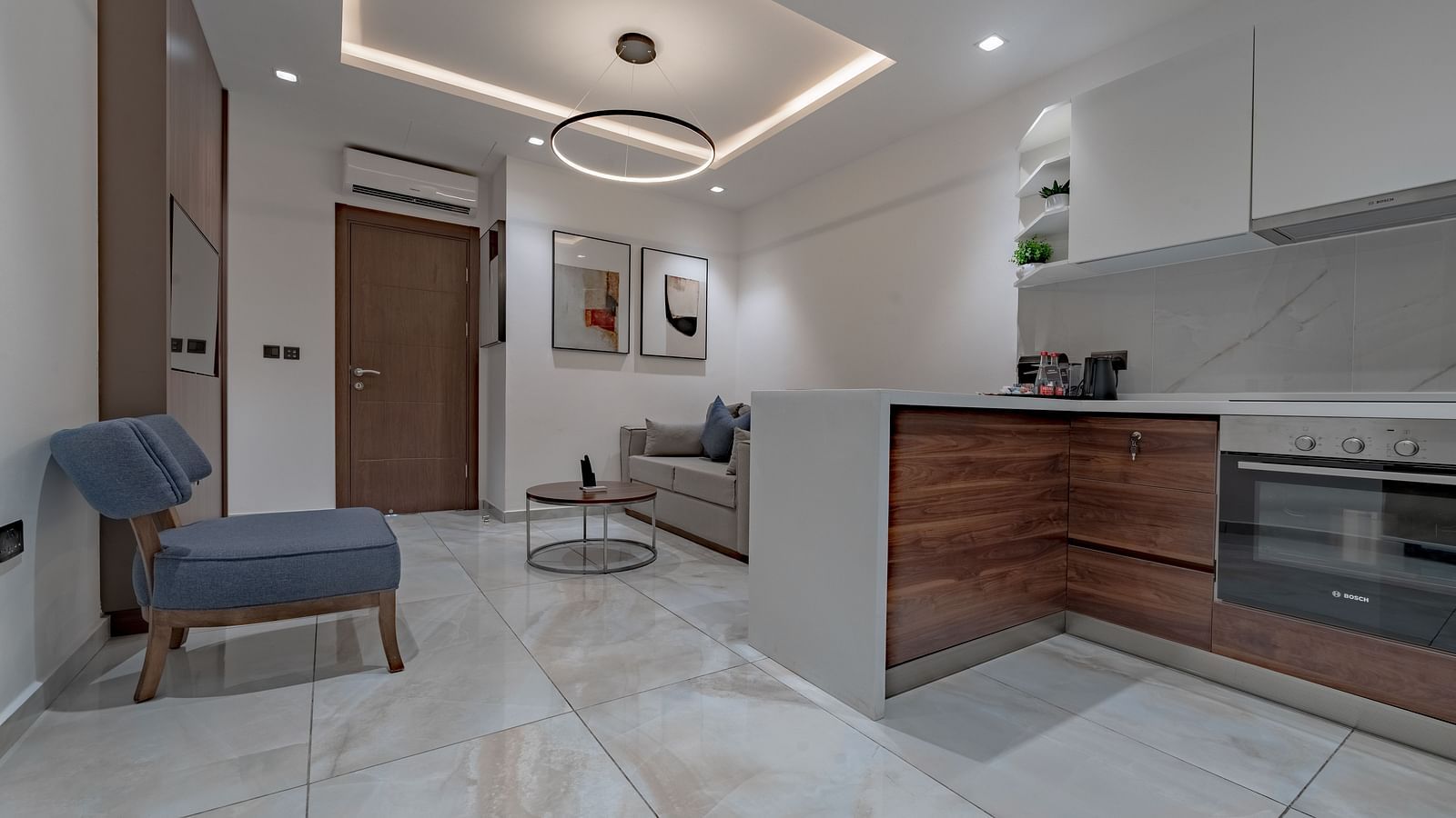 A well-lit Junior Suite with modern kitchen, stylish sofa, and elegant decor. - The Pelican Hotel, Accra