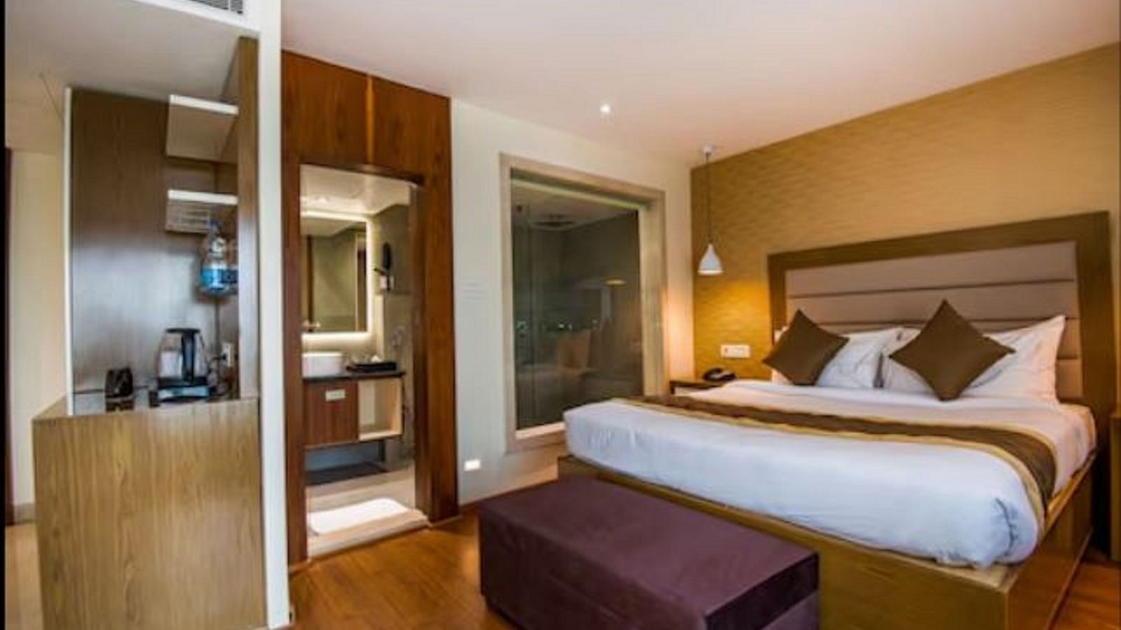 Image of a room at Yashshree The Imperial Inn siliguri with a bed, a purple table and other ameneties 