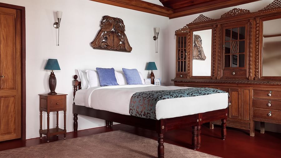 A wood furnished room with a bed, bedside tables, and a dresser - BluSalzz Villas - Muhamma Resort, Alleppey