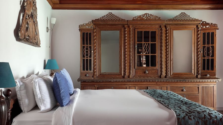 A shot of the room with a bed and a wooden dresser in the background - BluSalzz Villas - Muhamma Resort, Alleppey