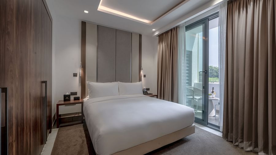 A spacious, well-lit Executive Suite featuring a king size bed and floor-to-ceiling windows - The Pelican Hotel, Accra - Place To Stay in Accra, Ghana, with Family.