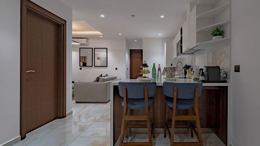 Modern Executive Suite with kitchen island, bar stools, and open floor plan. - The Pelican Hotel, Accra
