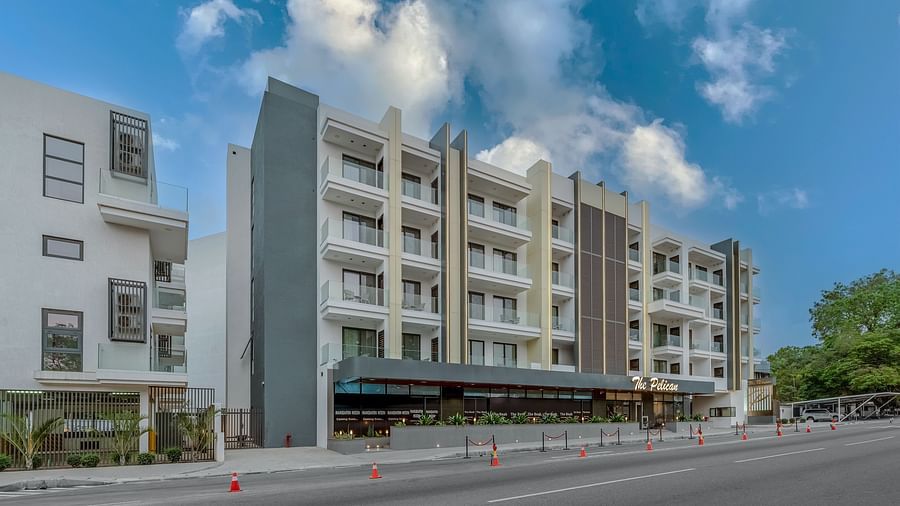 A multi-story hotel building with a covered walkway and a street in front. - The Pelican Hotel, Accra