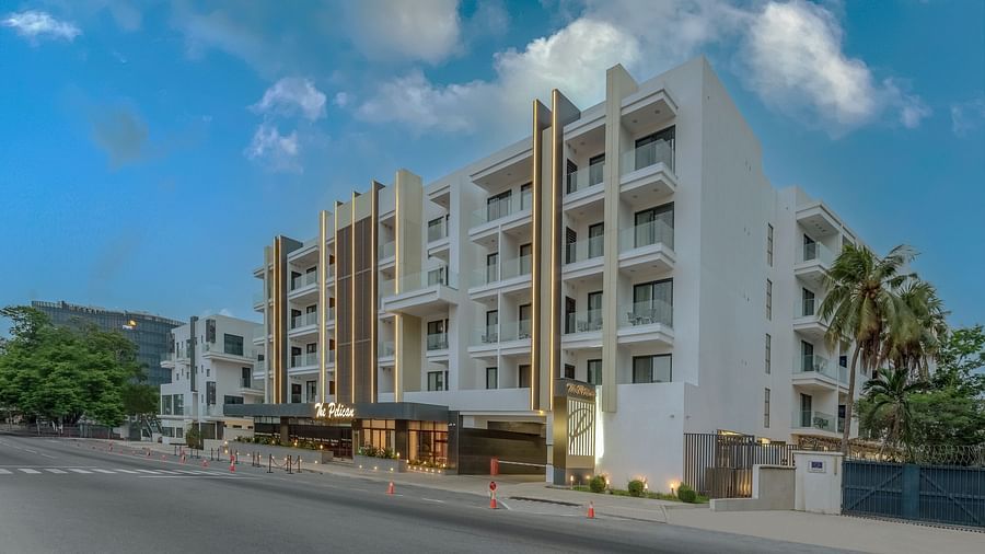 A rendering of a white two-story hotel with palm trees and a blue sky in the background. - The Pelican Hotel, Accra