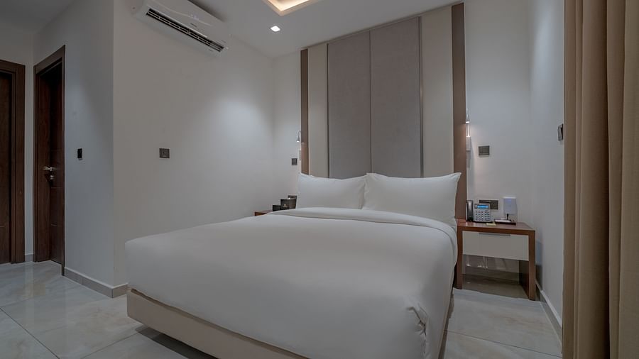Elegant, spacious Deluxe Room with a comfortable bed, bedside tables, and modern decor. - The Pelican Hotel, Accra