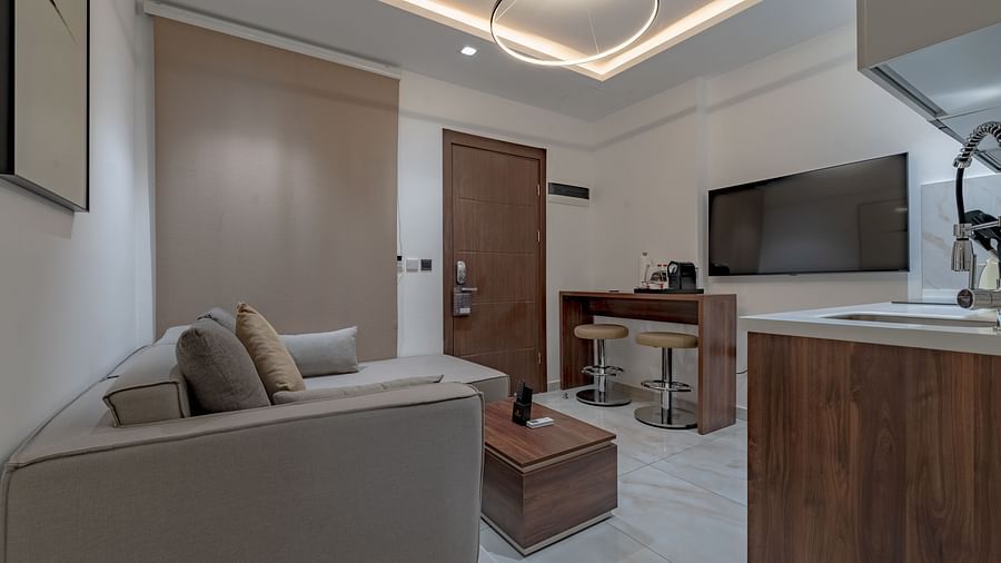 Modern, well-equipped kitchen in a Deluxe Room with wooden cabinetry and stainless steel appliances. - The Pelican Hotel, Accra