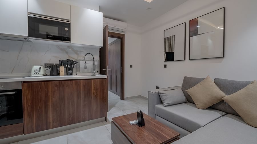A bright, modern Junior Suite with a sofa, and a kitchenette. - The Pelican Hotel, Accra