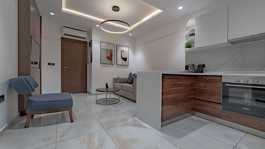 A well-lit Junior Suite with modern kitchen, stylish sofa, and elegant decor. - The Pelican Hotel, Accra