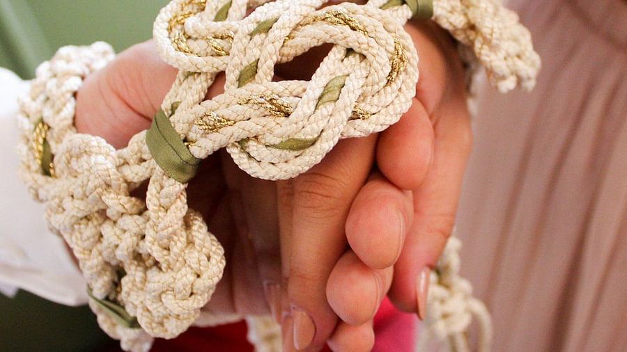 Close-up of hands with entwined ropes symbolizing unity