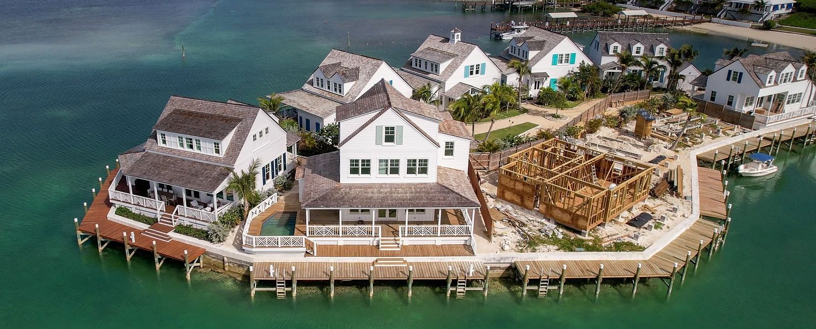 Overwater villas stretch along a calm shoreline, surrounded by a marina in a resort setting | Abaco Inn