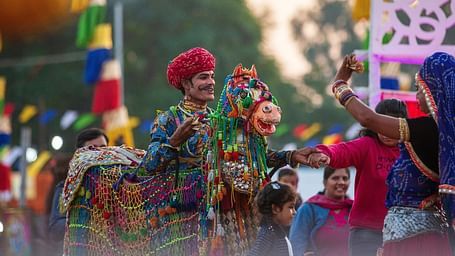 People in colorful clothing and flags at a festival.