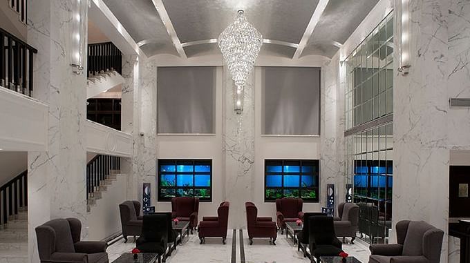 Dining hall or banquet space with seating arranged along rows and a flower arrangement in the centre.