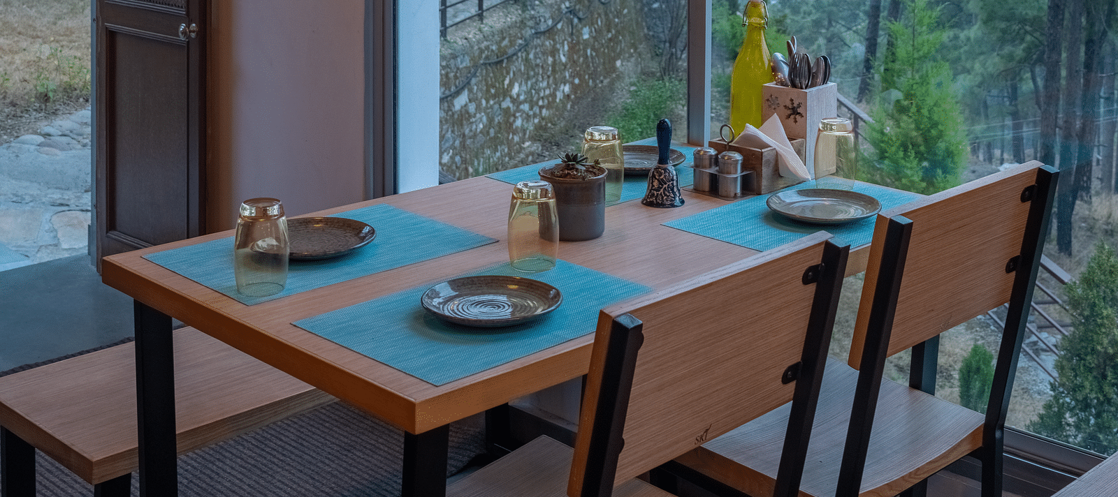A restaurant with a large glass window beside it, offering a view of the interior dining area at BluSalzz Escapade Resort, Lansdowne