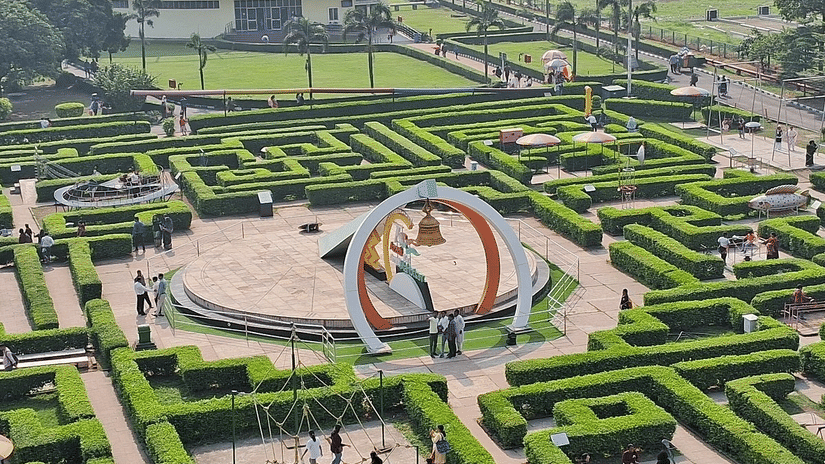 Landscaped grounds with geometric gardens and a large circular structure at Science City, Kolkata.