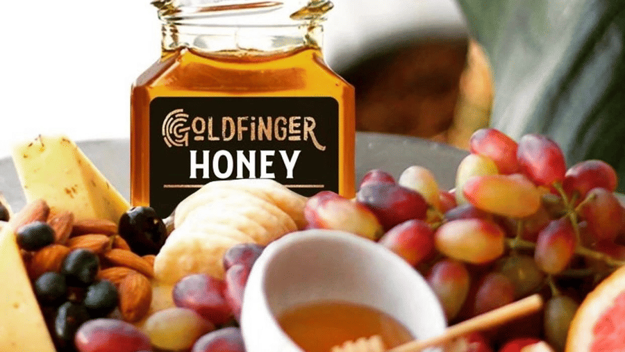 Interior view of Goldfinger Gift Shop at Hotel 39 Jamaica showcasing jars of honey, gourmet products, and local specialties, arranged neatly in a bright and inviting retail space.