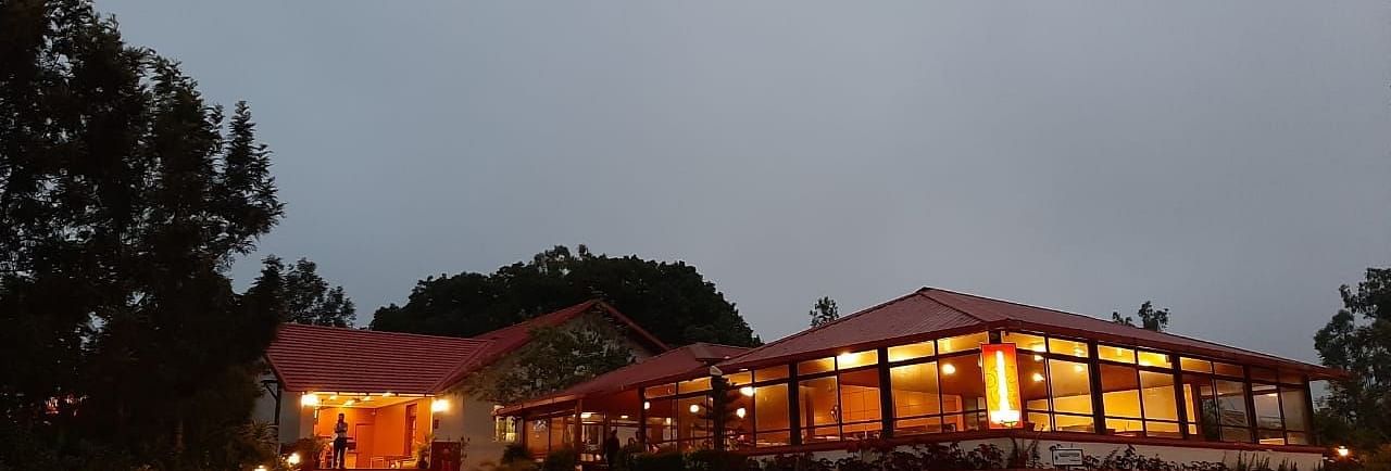 An evening view of Woodstock Resorts, Coorg highlighting the outdoor lighting and architecture.