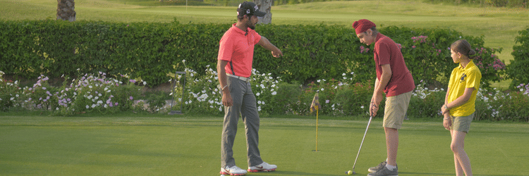 A group of people playing golf in the golf course of Karma Lakelands.