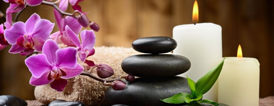  a spa set up with candles, flowers and hot stones 2
