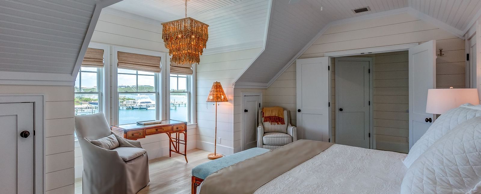 Bedroom with a king size bed, armchair, and sloped ceiling | Abaco Inn